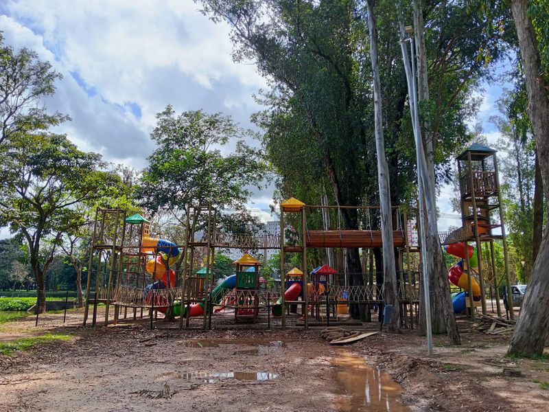 Vista ampla do kidsplay com duas torres altas ligadas por pontes de corda e um túnel de madeira